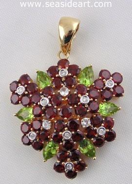A Ladie's 14kt Yellow Gold Pendant with diamond, white sapphire, garnet and peridot.